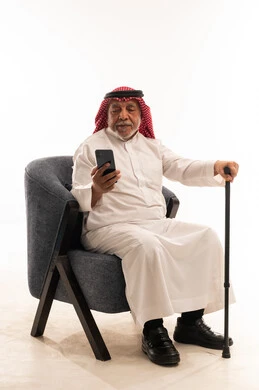 Elderly Saudi Man Using Smartphone with Walking Cane