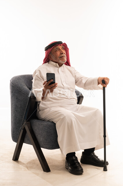Elderly Saudi Man with Smartphone and Walking Cane