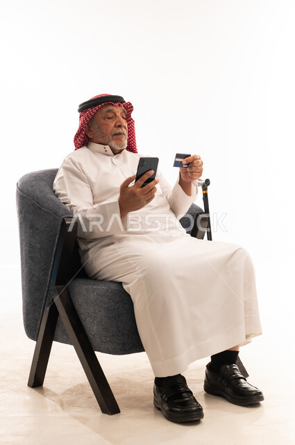 رجل سعودي مسن يستخدم بطاقة ائتمان وهاتف ذكي