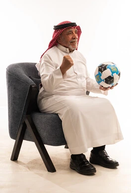 رجل سعودي مسن يحتفل بكرة قدم في الاستوديو