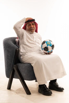 Elderly Saudi Man with Football Reacting to Loss