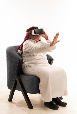Senior Saudi Man Using VR Headset and Traditional Thobe
