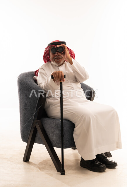رجل سعودي مسن مع منظار وعصا مشي