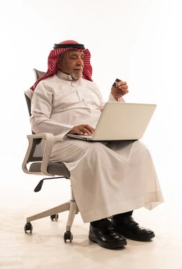 Elderly Saudi Man Using Laptop and Credit Card