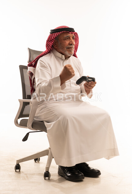 رجل سعودي مسن يلعب ألعاب الفيديو في الاستوديو