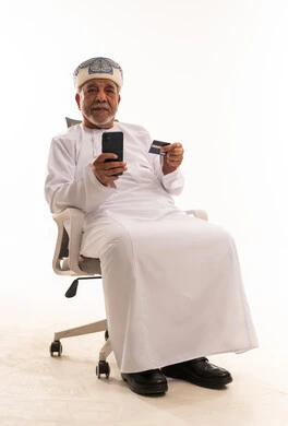 Omani Man Using Smartphone and Credit Card