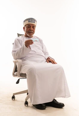 Omani Senior Man in Traditional Dress Holding a Card