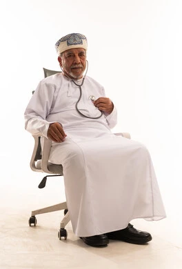 رجل عماني مسن يستخدم سماعة طبية بخلفية بيضاء