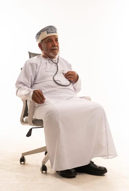 رجل عماني بالزي التقليدي يستخدم سماعة طبية