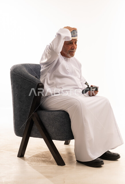 رجل عماني مسن محبط يلعب ألعاب الفيديو