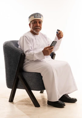 Senior Omani Man Using Smartphone and Credit Card Payment