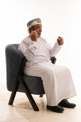 رجل عماني مسن يستخدم بطاقة الائتمان عبر الهاتف