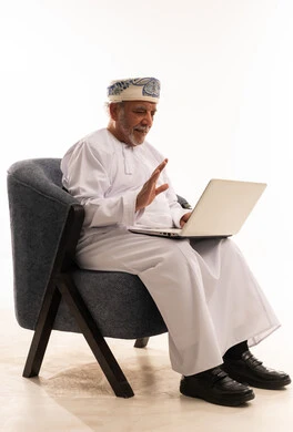 رجل عُماني مسن يستخدم جهاز الكمبيوتر المحمول في اتصال مرئي