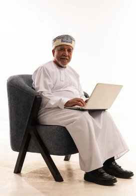 رجل عماني مسن يستخدم المحمول بالزي التقليدي