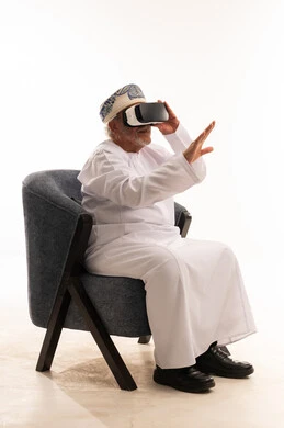 Elderly Omani Man Using VR Headset on White Background