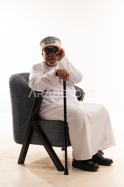 رجل عماني مسن مع منظار في الاستوديو