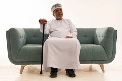 Elderly Omani Man in Traditional Dress with Walking Cane