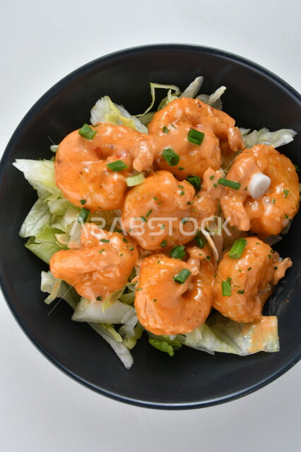 Close-up of a plate of delicious shrimp with different flavors of sauce, a plate of delicious appetizers, white background, fast food, Arabic restaurants, delicious seafood