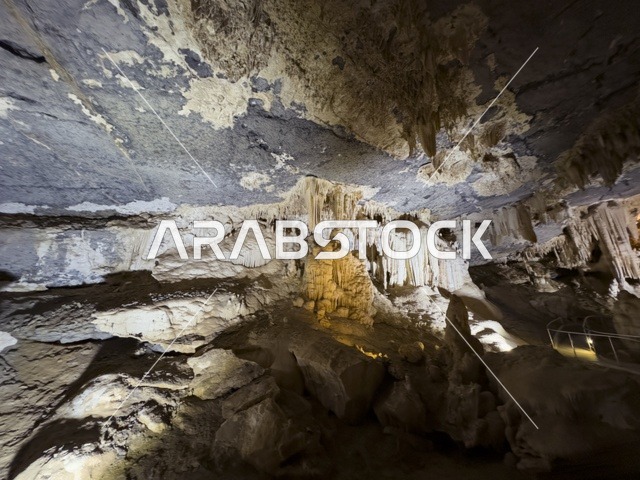 منظر داخلي لكهف الهوته في سلطنة عمان يظهر التكوينات الصخرية الطبيعية والممرات المضاءة في أجواء جيولوجية مذهلة.