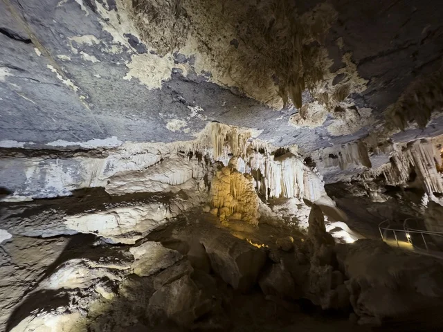 منظر داخلي لكهف الهوته في سلطنة عمان يظهر التكوينات الصخرية الطبيعية والممرات المضاءة في أجواء جيولوجية مذهلة.