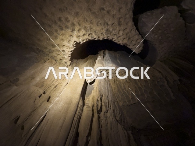 منظر داخلي لكهف الهوته في سلطنة عمان يظهر التكوينات الصخرية الطبيعية والممرات المضاءة في أجواء جيولوجية مذهلة.