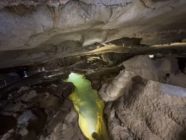 منظر داخلي لكهف الهوته في سلطنة عمان يظهر التكوينات الصخرية الطبيعية والممرات المضاءة في أجواء جيولوجية مذهلة.