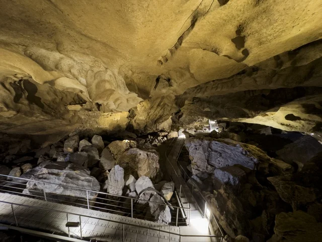 منظر داخلي لكهف الهوته في سلطنة عمان يظهر التكوينات الصخرية الطبيعية والممرات المضاءة في أجواء جيولوجية مذهلة.