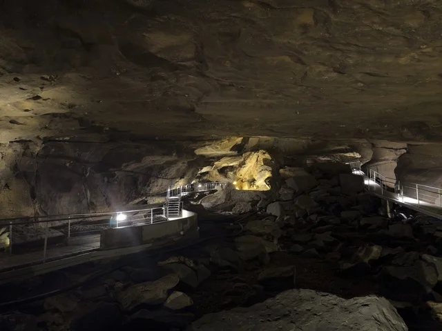 منظر داخلي لكهف الهوته في سلطنة عمان يظهر التكوينات الصخرية الطبيعية والممرات المضاءة في أجواء جيولوجية مذهلة.