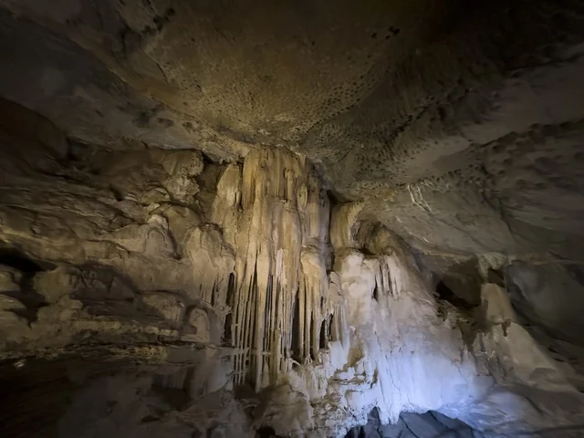 منظر داخلي لكهف الهوته في سلطنة عمان يظهر التكوينات الصخرية الطبيعية والممرات المضاءة في أجواء جيولوجية مذهلة.