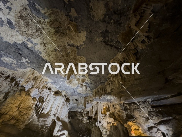 منظر داخلي لكهف الهوته في سلطنة عمان يظهر التكوينات الصخرية الطبيعية والممرات المضاءة في أجواء جيولوجية مذهلة.
