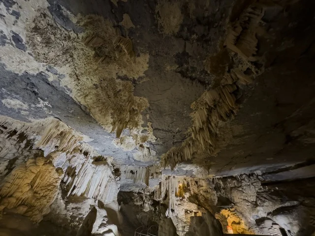 منظر داخلي لكهف الهوته في سلطنة عمان يظهر التكوينات الصخرية الطبيعية والممرات المضاءة في أجواء جيولوجية مذهلة.