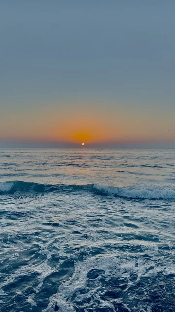 Sunset over Ocean Waves in Sultanate of Oman