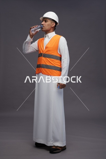عامل سعودي بمعدات السلامة يشرب الماء