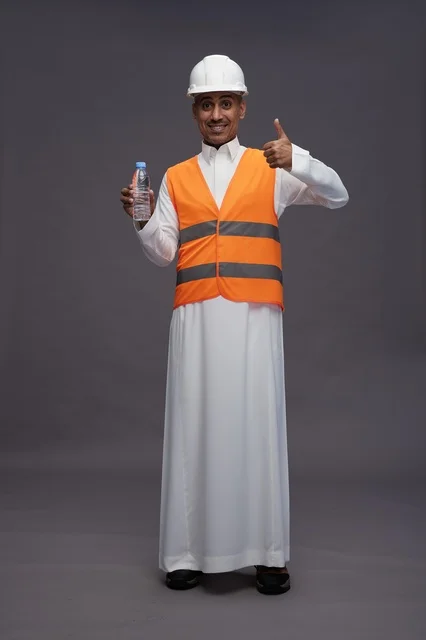 Saudi Worker in Safety Gear Holding Water Bottle