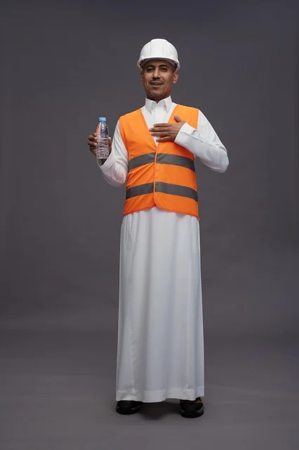 Saudi Worker in Safety Gear Holding Water Bottle