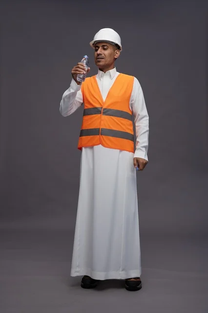 Saudi Worker in Safety Vest Holding Water Bottle