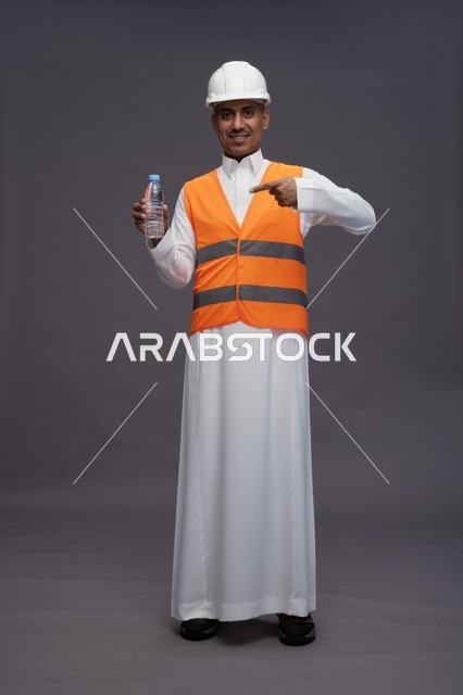 عامل سعودي بمعدات السلامة يحمل زجاجة ماء