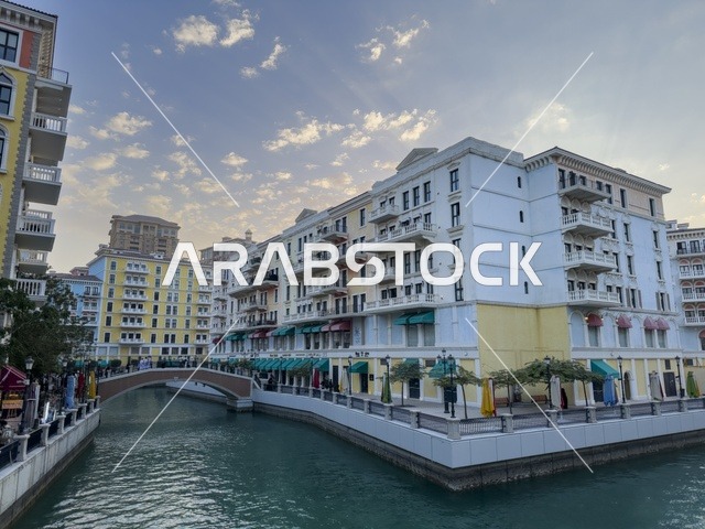 قناة كارتية في جزيرة اللؤلؤة بالدوحة تظهر المباني الفاخرة وانعكاس الأضواء على المياه في مشهد أنيق.