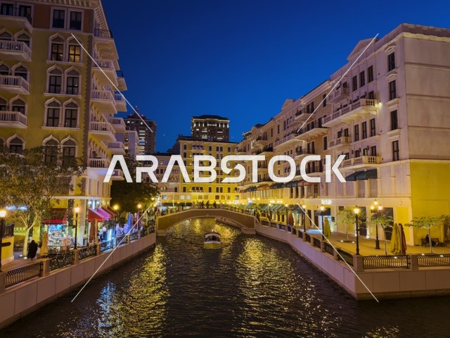 قناة كارتية في جزيرة اللؤلؤة بالدوحة تظهر المباني الفاخرة وانعكاس الأضواء على المياه في مشهد أنيق.