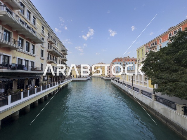 قناة كارتية في جزيرة اللؤلؤة بالدوحة تظهر المباني الفاخرة وانعكاس الأضواء على المياه في مشهد أنيق.