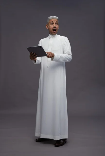 رجل سعودي يتفاعل مع جهاز لوحي بالزي التقليدي