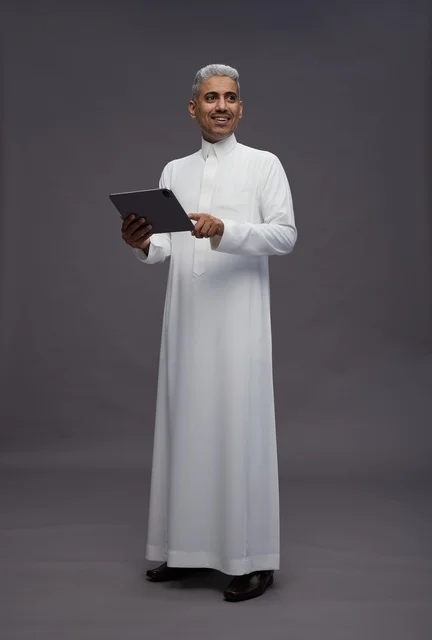 رجل سعودي يتفاعل مع جهاز لوحي بالزي التقليدي