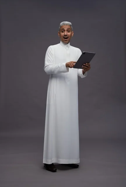 رجل سعودي يتفاعل مع جهاز لوحي بالزي التقليدي
