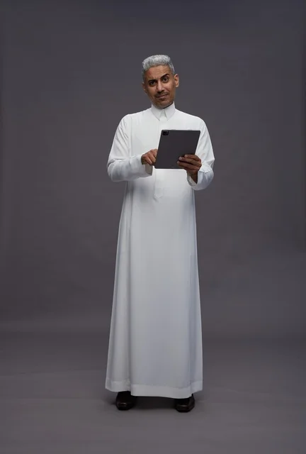رجل سعودي يتفاعل مع جهاز لوحي بالزي التقليدي