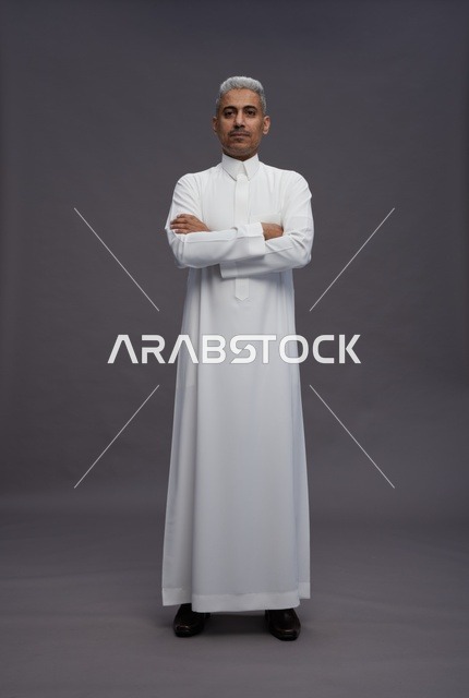 رجل سعودي بالثوب الأبيض بوضعية ذراعين متقاطعتين