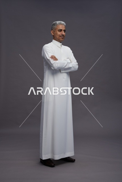 رجل سعودي بالثوب الأبيض بوضعية ذراعين متقاطعتين