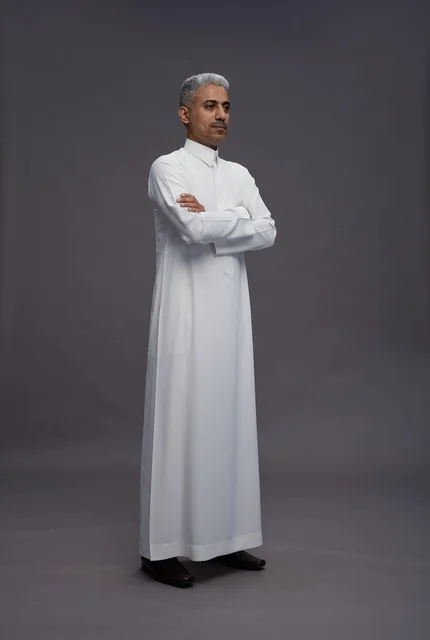 رجل سعودي بالثوب الأبيض بوضعية مكتوفة الأيدي