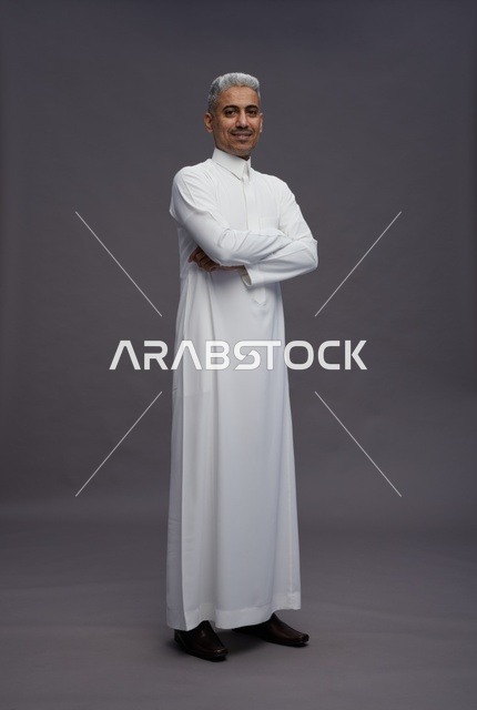 رجل سعودي بالثوب الأبيض بوضعية مكتوف الأيدي