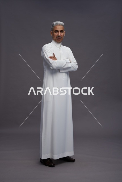 رجل سعودي بالثوب الأبيض بخلفية رمادية