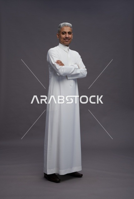 رجل سعودي بالثوب الأبيض بوضعية ذراعين متقاطعين